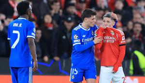 Vinicius Junior mencetak gol tunggal kemenangan Real Madrid atas Benfica pada laga leg pertama knockout play-off Liga Champions musim ini di Estadio da Luz, Lisbon, Rabu (18/02/2026) dini hari WIB. Sayangnya dalam duel tersebut, Vincius menjadi korban tindakan rasisme yang dilakukan pendukung dan pemain Benfica, Gianluca Prestianni (kanan). (AFP/PATRICIA DE MELO MOREIRA)