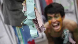 Mahasiswa melakukan aksi teatrikal yang menggambarkan pendidikan di Indonesia yang masih terbelenggu oleh uang, dalam rangka memperingati Hari Pendidikan Nasional (Hardiknas) di Bundaran HI, Jakarta, Minggu (3/5/2015). (Liputan6.com/Faizal Fanani)