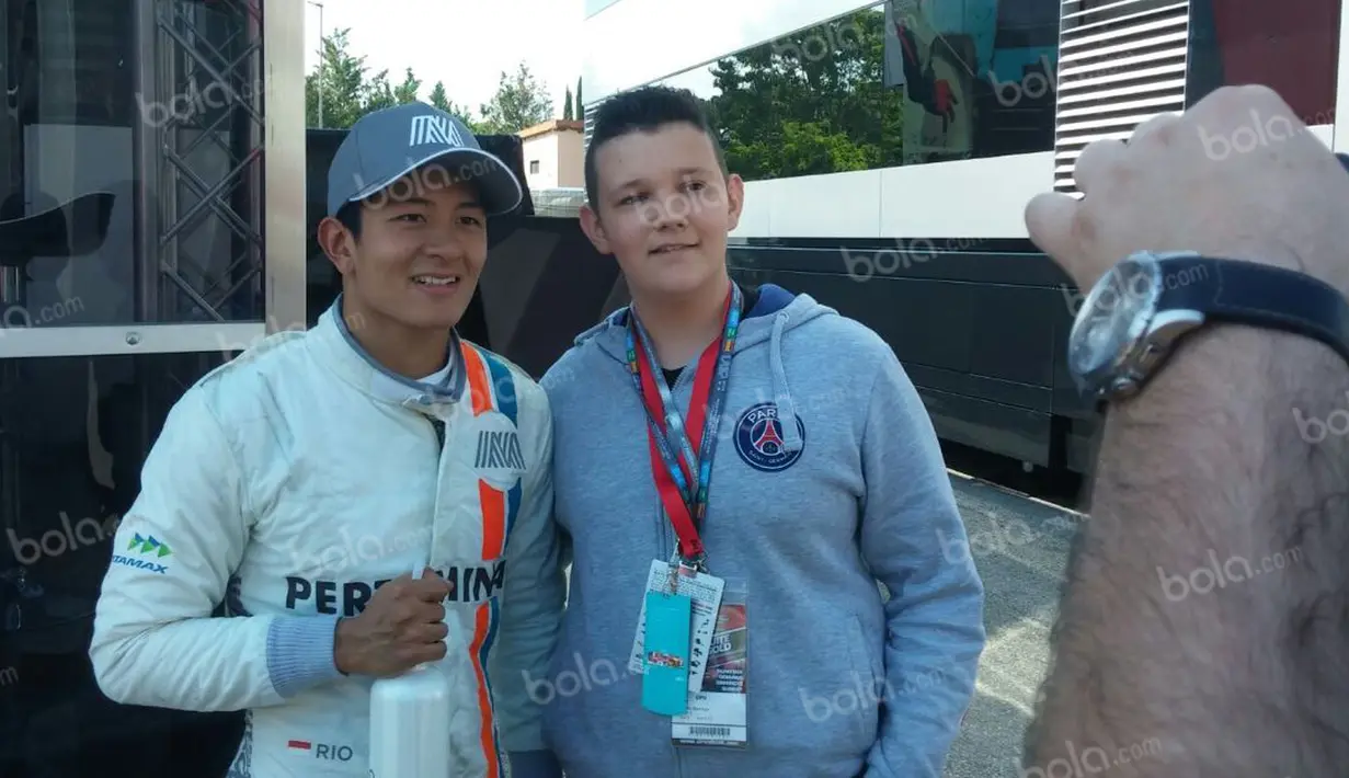 Pebalap Manor Racing asal Indonesia, Rio Haryanto, berfoto dengan seorang penggemar seusai balapan F1 GP Spanyol di Sirkuit Catalunya, Spanyol, Minggu (15/5/2016). (Bola.com/Reza Khomaini)