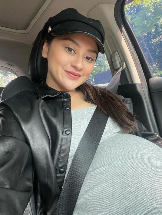 Dalam unggahan terbaru, Memes membagikan lima potret hasil swafotonya yang menampilkan baby bump yang makin besar. Dengan makeup flawless, wanita kelahiran 29 Agustus 1996 itu tampil dengan baju abu-abu dan outer berupa jaket hitam. Ia juga melengkapi penampilannya dengan topi dan rambut diikat. (Liputan6.com/IG/@memes_prameswari)