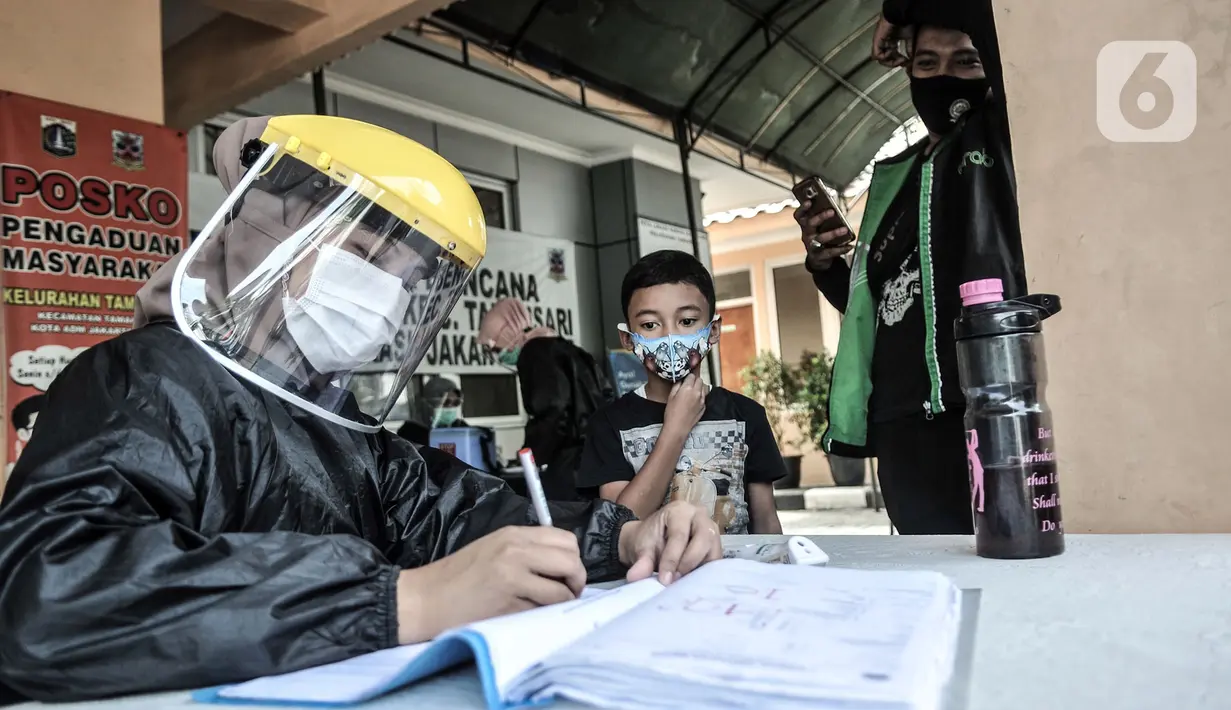 Petugas paramedis mendata salah seorang anak sebelum mengikuti program BIAS di Kantor Kelurahan Tamansari, Jakarta, Selasa (24/11/2020). BIAS merupakan program tahunan pemerintah yang berjalan dua kali dalam setahun, Agustus dan November. (merdeka.com/Iqbal S. Nugroho)