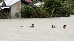 Sejumlah warga Filipina memeriksa jaring ikan yang mereka pasang saat banjir melanda wilayah mereka di Kota Condon, Ilocos sur, Filipina, Senin (24/8/2015). Banjir tersebut akibat hujan deras yang dibawa oleh Topan Goni. (AFP Photo)