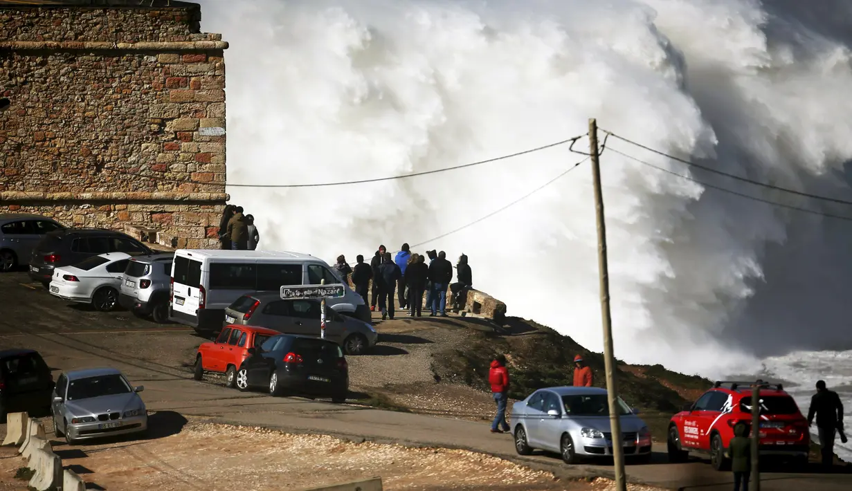 Warga berkumpul untuk menonton pertunjukan para peselancar dunia di Praia do Norte, Nazare,Portugal, (19/2/16). Peselancar asal Amerika Garrett McNamara pernah menakhlukan ombak setinggi 23.77 Meter. (REUTERS/Rafael Marchante)