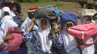 Para murid menggunakan tas untuk pelindung dalam latihan tsunami di Meulaboh (5/9). Sebanyak 24 negara yang berbatasan dengan Samudra Hindia, dari Australia hingga Yaman, mengambil bagian dalam latihan kesiapsiagaan bencana dua tahunan. (AFP Photo/Januar)
