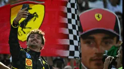 Pembalap Ferrari, Charles Leclerc melakukan swafoto saat berada di atas podium Formula 1 GP Italia 2024 yang berlangsung di Sirkuit Monza, Italia, Minggu (01/09/2024). (AFP/Gabriel Bouys)