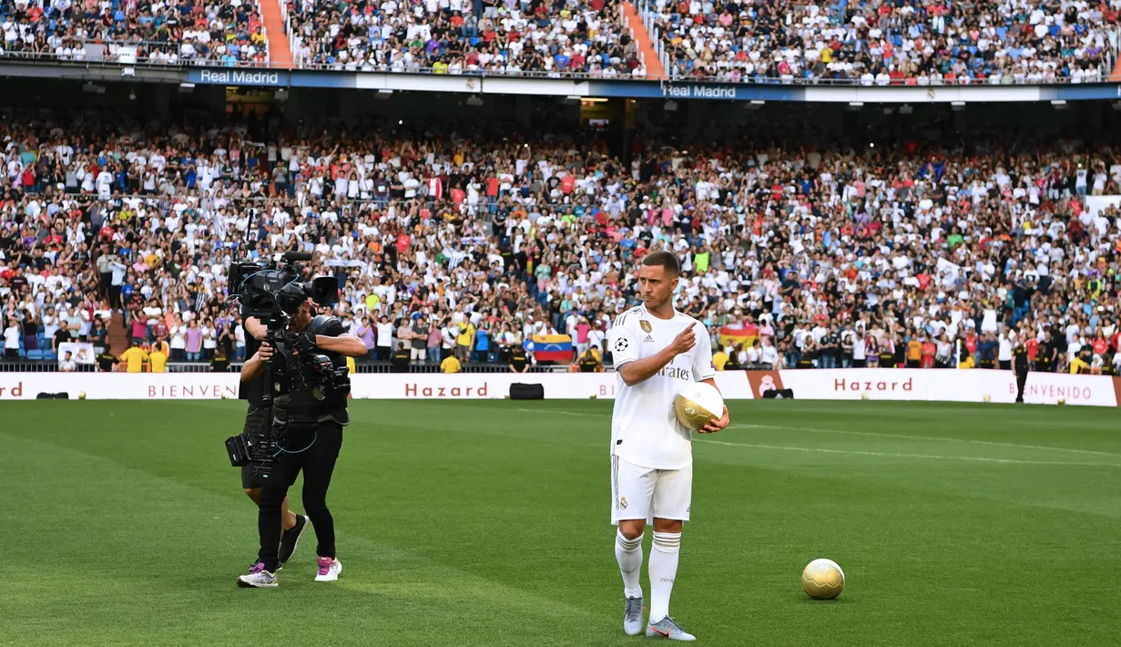 Gelandang Real Madrid, Eden Hazard, menyapa suporter saat perkenalan dirinya di Stadion Santiago Bernabeu, Madrid, Kamis (13/6). Dirinya didatangkan Madrid dari Chelsea dengan kontrak lima musim. (AFP/Gabriel Bouys)