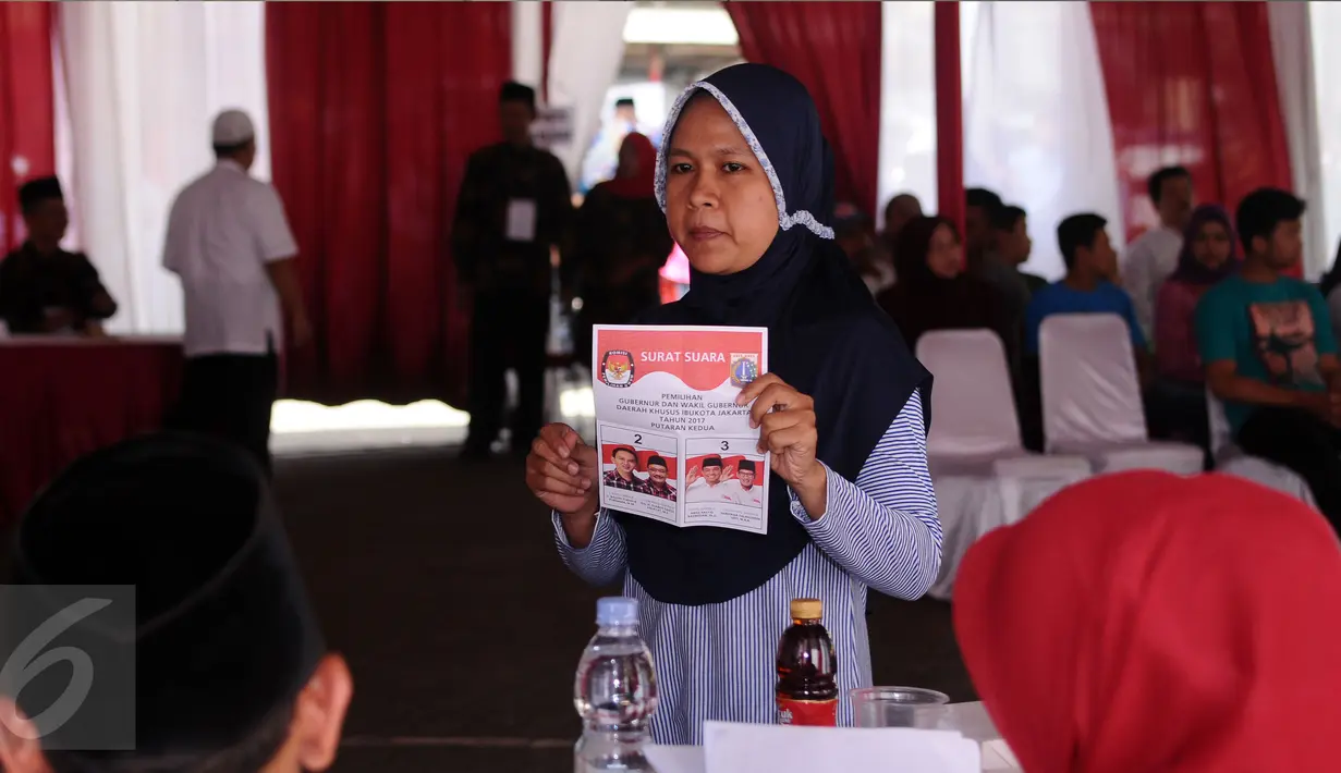 Warga menunjukkan surat suara Pilkada DKI Jakarta putaran 2 di TPS 027 Kebagusan, Jakarta, Rabu (19/4). (Liputan6.com/Helmi Fithriansyah)