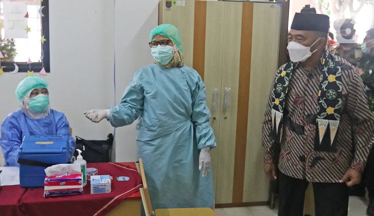 Menko PMK Muhadjir Effendy (kanan) meninjau vaksinasi COVID-19 di SDN 01 Depok, Depok, Jawa Barat, Selasa (14/12/2021). Kunjungan tersebut untuk melihat persiapan vaksinasi COVID-19 anak usia 6-11 tahun yang dilaksanakan mulai hari ini. (Liputan6.com/Herman Zakharia)