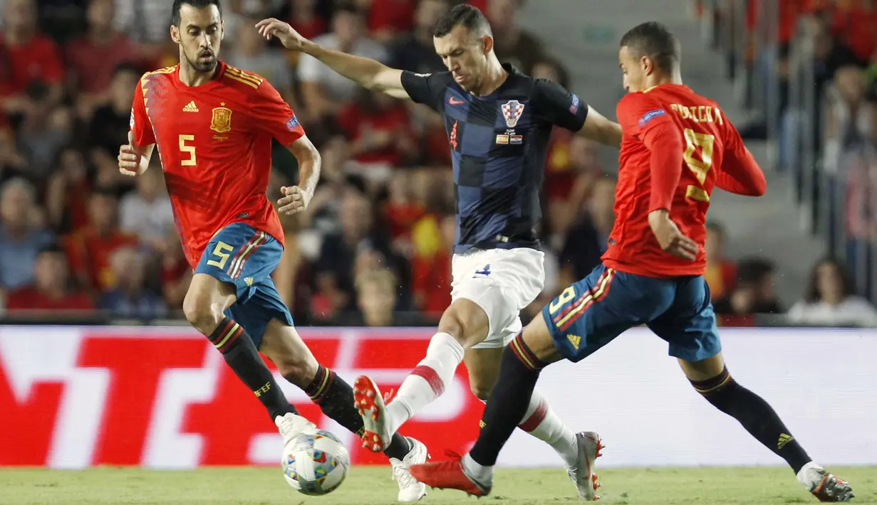Striker Spanyol, Rodrigo Moreno, berusaha menghadang gelandang Kroasia, Ivan Perisic, pada laga UEFA Nations League di Stadion Manuel Martinez Valero, Selasa (11/9/2018). Spanyol menang 6-0 atas Kroasia. (AP/Alberto Saiz)