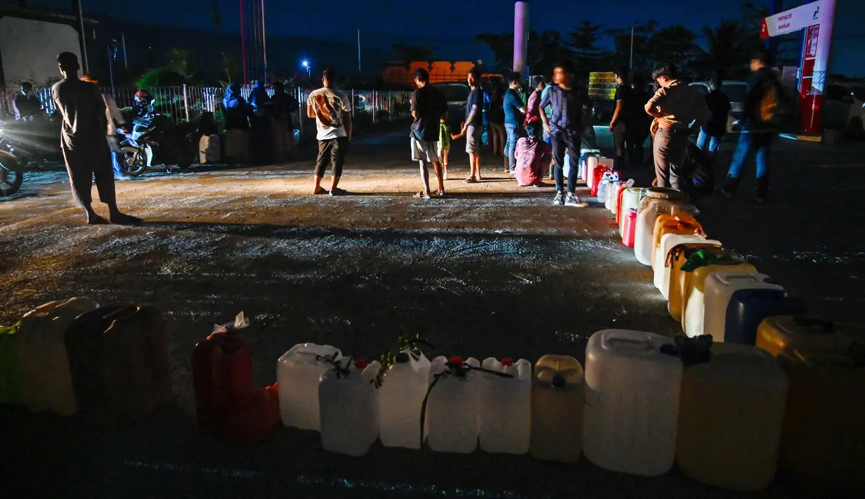 Beberapa SPBU bahkan terpaksa menutup operasional karena tidak memiliki jenis BBM yang memadai untuk dijual kepada masyarakat. Tampak dalam foto, warga terdampak banjir mengantre untuk mendapatkan bahan bakar di sebuah Stasiun Pengisian Bahan Bakar Umum (SPBU) di Samahani, Provinsi Aceh, pada 2 Desember 2025. (CHAIDEER MAHYUDDIN/AFP)