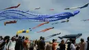 Penonton menyaksikan layang-layang raksasa yang terbang selama Festival Internacional del Viento di pantai Malvarrosa, di Valencia, Spanyol (23/4). Acara ini diikuti oleh 150 peserta dari berbagai penjuru Eropa. (AFP/Jose Jordan)