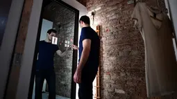 Wesley Bliss menunjukkan cara berinteraksi dengan cermin pintar Oak Fitting Room di sebuah butik, New York, AS (7/2). Cermin ini juga dapat mengukur tubuh sehingga merekomendasikan pakaian yang cocok. (AFP Photo / Jewel Samad)