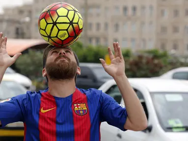 Reza Parastesh, seorang warga Iran yang memiliki wajah mirip Lionel Messi melakukan juggling di jalanan Tehran, Iran, Senin (8/5/2017). (AFP/Atta Kenare)