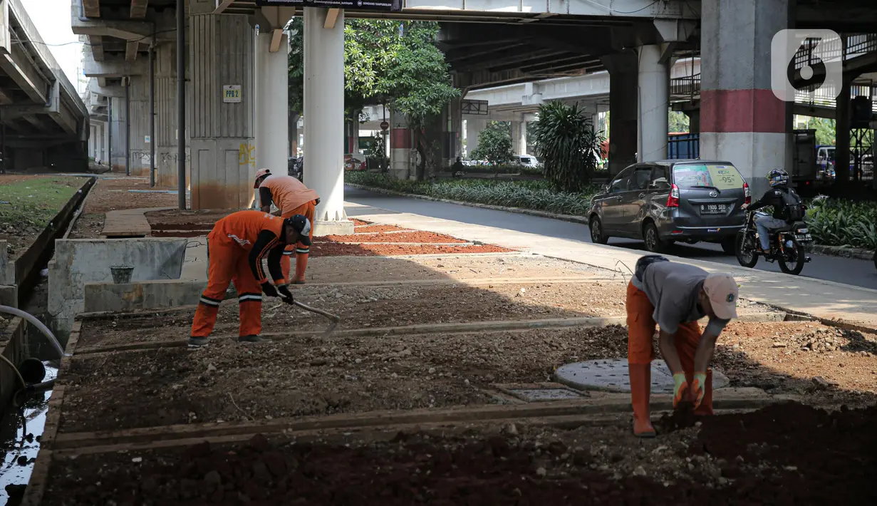 Sejumlah petugas PPSU menanam pohon di kolong Tol Becakayu, Jakarta, Kamis (12/1/2023). Pemerintah Provinsi DKI Jakarta melakukan penataan lahan melalui program penghijauan sepanjang lima kilometer di tepi saluran Kalimalang  kolong tol Bekasi Cawang Kampung Melayu (Becakayu), Jakarta Timur untuk menjaga mutu air baku Jakarta. (Liputan6.com/Faizal Fanani)