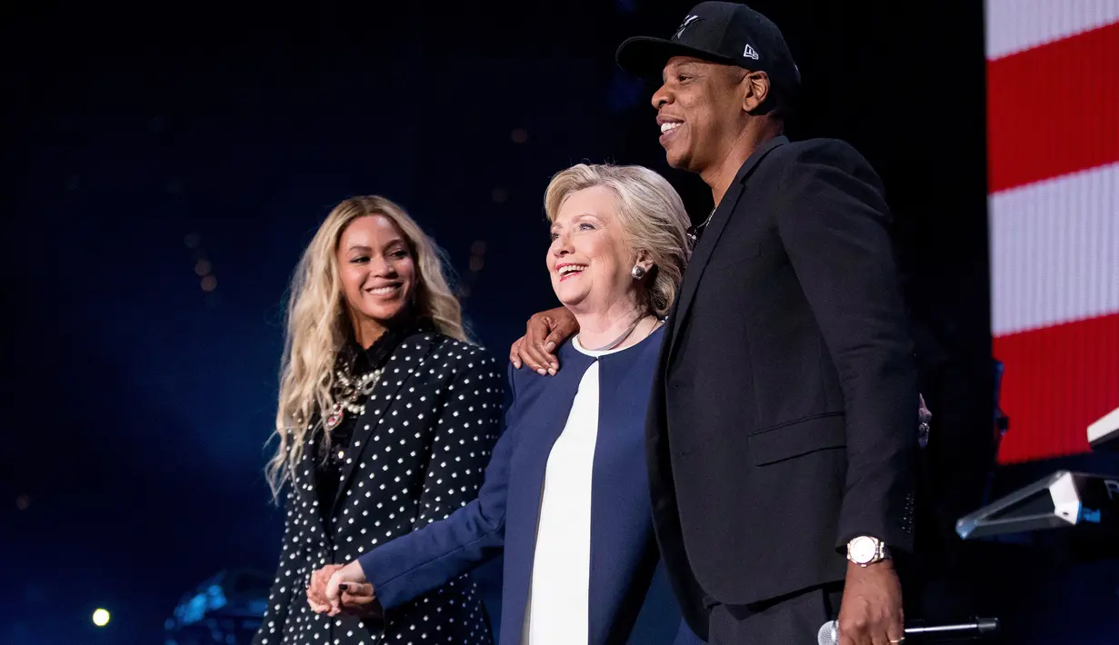 Penyanyi Beyonce dan suaminya, Jay Z berdiri bersama Capres AS Hillary Clinton dalam konser kampanye di Cleveland, Ohio, Jumat (4/11). Jay Z dan Beyonce menggelar konser bagi Hillary untuk meraih pemilih muda berkulit hitam di Ohio. (AP Photo/Matt Rourke)