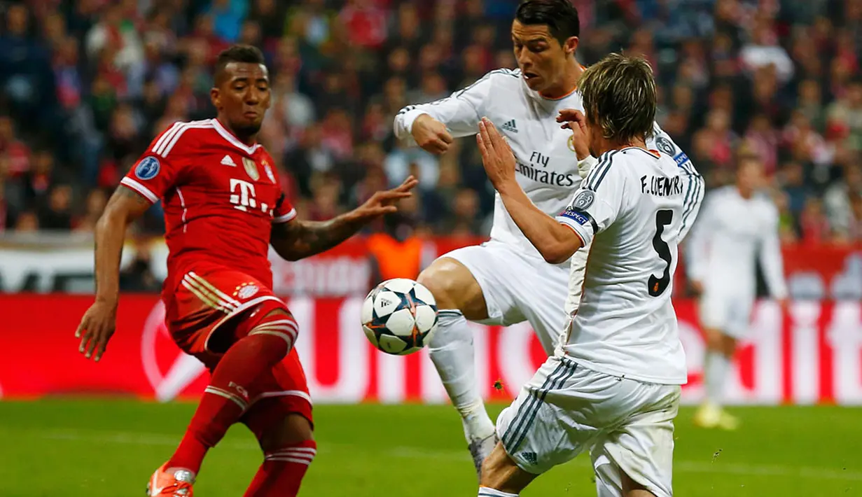 Bek tengah Bayern Munich, Jerome Boateng (kiri) mencoba menahan laju serangan dua pemain Real Madrid, Cristiano Ronaldo dan Fabio Coentrao, saat laga kedua semifinal Liga Champions di Allianz Arena, Munich (30/4/2014). (REUTERS/Michael Dalder)