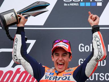 Pembalap Repsol Honda Tim MotoGP Marc Marquez mengangkat trofi usai menjuarai Grand Prix MotoGP di Sirkuit Sachsenring, Jerman, Minggu (12/7/2015). Pembalap asal Spanyol ini menduduki peringkat pertama pada seri sembilan ini. (REUTERS/Hannibal Hanschke)