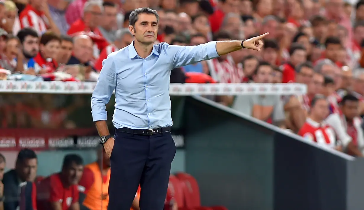 Pelatih Barcelona,  Ernesto Valverde menginstruksikan pemainnya saat bertanding melawan Athletic Bilbao pada pertandingan perdana La Liga Spanyol di Stadion San Mames, Sabtu (17/8/2019). Bilbao menang tipis atas Barcelona dengan skor 1-0. (AFP Photo/Ander Gillenea)