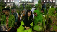 Menko PMK Puan Maharani berbincang dengan Mensos Khofifah Indar Parawansa saat menghadiri pelantikan pengurus Muslimat NU dan peringatan Harlah Muslimat NU yang Ke 71, Jakarta, Selasa (28/3). (Liputan6.com/Faizal Fanani)