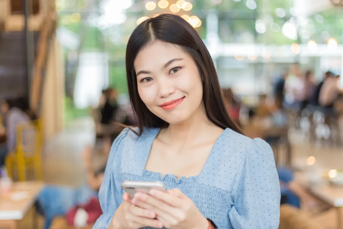 dewasa mandiri bahagia pegang handphone di kafe kalem