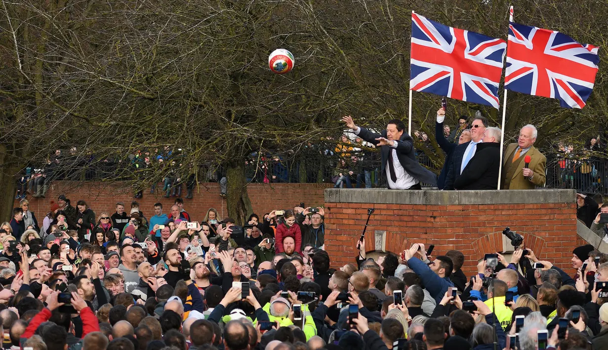 Para peserta berebut bola saat dimulainya Royal Shrovetide Football Match di Ashbourne, Derbyshire, Inggris, Selasa (5/3). Permainan sejak abad 12 ini diyakini sebagai awal munculnya istilah 'derby' yang berasal dari kata 'Derbyshire'. (Oli Scarff/AFP)