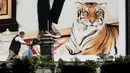 Seorang pekerja berjalan melewati iklan yang menampilkan macan di depan pusat perbelanjaan jelang Tahun Baru Imlek di Taipei, Taiwan, Kamis (27/1/2022). Tahun Baru Imlek 2022 yang jatuh pada 1 Februari mendatang akan jadi tahun shio macan. (Sam Yeh/AFP)