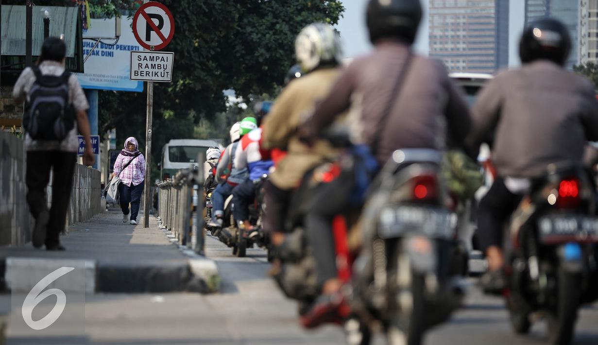 Seorang pejalan kaki melintas melalui trotoar dikawasan Sudirman, Jakarta, Senin (18/4). Gubernur Basuki T Purnama berencana memperlebar trotoar sampai 9,5 meter agar mempermudah orang berjalan kaki usai naik kereta atau bus. (Liputan6.com/Faizal Fanani)