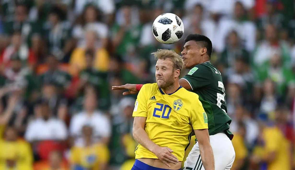 Pemain Swedia, Ola Toivonen (kiri) melakukan duel udara dengan pemain Meksiko, Jesus Gallardo pada laga grup F Piala Dunia 2018 di Yekaterinburg Arena, Yekaterinburg, Rusia, (27/6/2018).  Swedia menang telak 3-0 atas Meksiko. (AP/Martin Meissner)