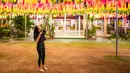 Seorang perempuan menggantung lampion di Wat Phra That Hariphunchai, Lamphun, Thailand, 1 November 2020. Sekitar 100.000 lampion digantung di Wat Phra That Hariphunchai sebagai bagian dari perayaan festival tradisional Yi Peng. (Xinhua/Zhang Keren)