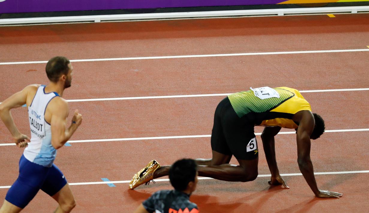 Pelari asal Jamaika, Usain Bolt terkapar di tengah lintasan setelah terjatuh di final 4x100 meter pada Kejuaraan Dunia Atletik di London, Sabtu (12/8). Bolt yang berencana ingin pensiun itu terjatuh karena kaki kirinya kram. (AP/Frank Augstein)
