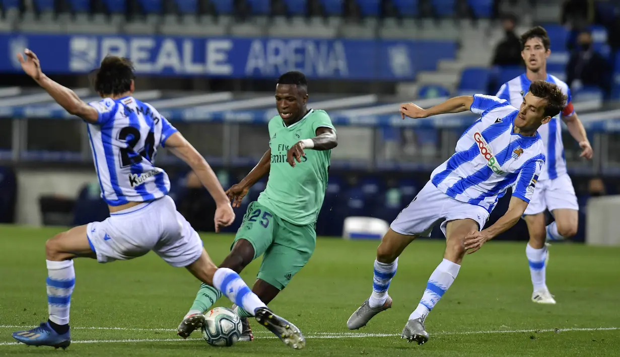 Pemain Real Madrid, Vinicius Junior, berusaha melewati pemain Real Sociedad pada laga La Liga di Reale Seguros Stadium, Minggu (21/6/2020). Real Madrid menang 2-1 atas Real Sociedad. (AP Photo/Alvaro Barrientos)