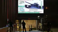 Seorang pria menonton layar TV besar yang menyiarkan berita tentang pasukan Rusia yang telah meluncurkan serangan mereka ke Ukraina, di Hong Kong Kamis, 24 Februari 2022. (AP/Vincent Yu)