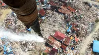 Penyemprotan cairan disinfektan di kawasan terdampak likuifaksi di Perumnas Petobo dan Balaroa, Palu, Sulawesi Tengah, Kamis (18/10). Penyemprotan dilakukan untuk mengantisipasi penyebaran penyakit. (Muhammad Rifki/AFP)