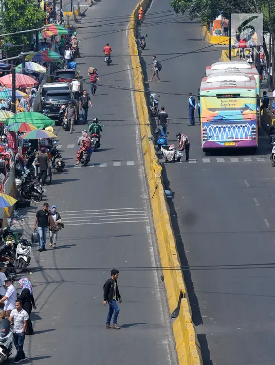 Pengendara motor melintasi Jalan Jatibaru di kawasan Tanah Abang, Jakarta, Selasa (19/6). Hingga H+4 Lebaran 2018 belum terlihat aktivitas pedagang kaki lima yang biasa berjualan di salah satu ruas jalan Jatibaru. (Liputan6.com/Helmi Fithriansyah)