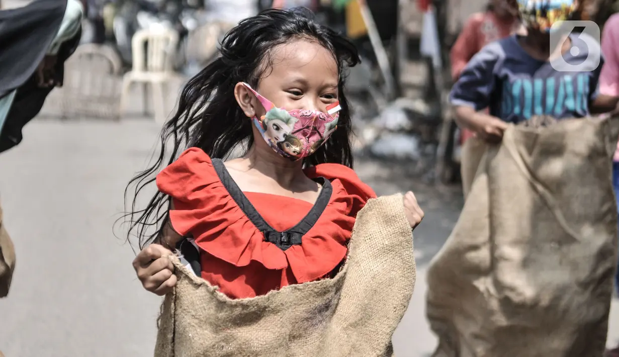 Anak-anak mengikuti lomba balap karung memperingati HUT ke-75 RI di Kampung Nelayan, Cilincing, Jakarta, Senin (17/8/2020). Meski dilarang menggelar perlombaan akibat Covid-19, warga di Kampung Nelayan tetap mengadakan lomba 17-an walaupun hanya beberapa jenis. (merdeka.com/Iqbal Nugroho)