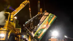 Alat berat mengevakuasi bangkai bus pariwisata Taiwan yang mengalami kecelakaan di ruas jalan dekat Taipe, Selasa (14/2). Kejadian nahas tersebut terjadi saat bus hendak membawa 44 turis berwisata melihat keindahan bunga sakura. (Ou Dongqu/Xinhua via AP)