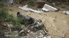 Sebuah mobil tergeletak di sungai setelah hujan lebat di Thessaloniki, Yunani utara, Sabtu, 17 Juni 2023. Rumah-rumah terendam banjir dan pohon-pohon tumbang serta mobil-mobil hanyut setelah hujan lebat di banyak pinggiran kota di bagian utara. (AP Photo/Giannis Papanikos)