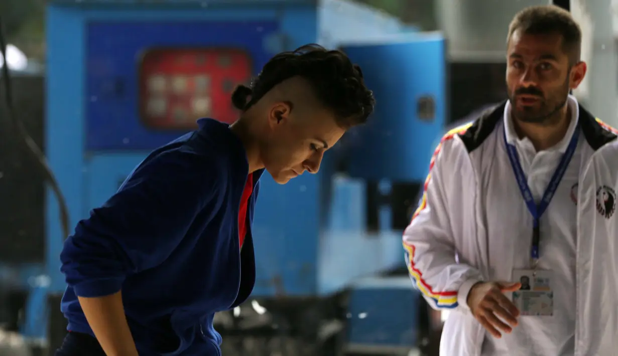 Seorang Atlet Wushu sedang mendengar instruksi Pelatihnya sebelum bertanding pada Kejuaraan Dunia Wushu 2015 di Istora, Senayan, Jakarta, Selasa (17/11/2015). (Bola.com/Nicklas Hanoatubun)