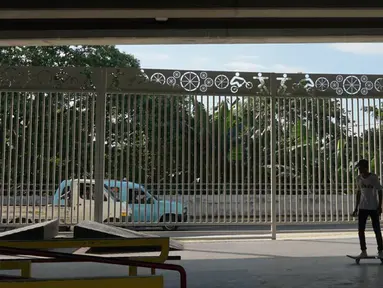 Seorang warga bermain skate board di fasilitas skate park kolong flyover Pasar Rebo, Jakarta, Selasa (14/1/2020). Skate park yang telah selesai dibangun tersebut kini mulai diramaikan pengunjung, khususnya pada sore hari. (Liputan6.com/Immanuel Antonius)