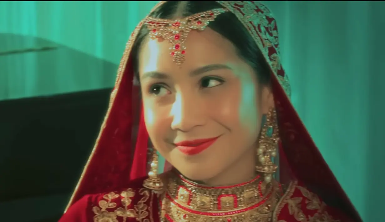 Wajahnya dipoles dengan blush on pink, serta lipstik merah matte. Matanya dihias soft mengenakan eyeliner. [YouTube Dewa19]