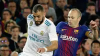 Pemain Barcelona, Andres Iniesta berebut bola dengan pemain Real Madrid, Karim Benzema pada pertandingan La Liga Spanyol di Stadion Camp Nou, Minggu (6/5). Barcelona bisa memaksakan hasil imbang dengan Real Madrid 2-2. (AP/Emilio Morenatti)