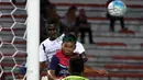 Bek T-Team Malaysia, Abdoulaye Maiga, duel udara dengan pemain ATM FA pada laga play-off Malaysia Super League 2016. (Bola.com/Nicklas Hanoatubun)
