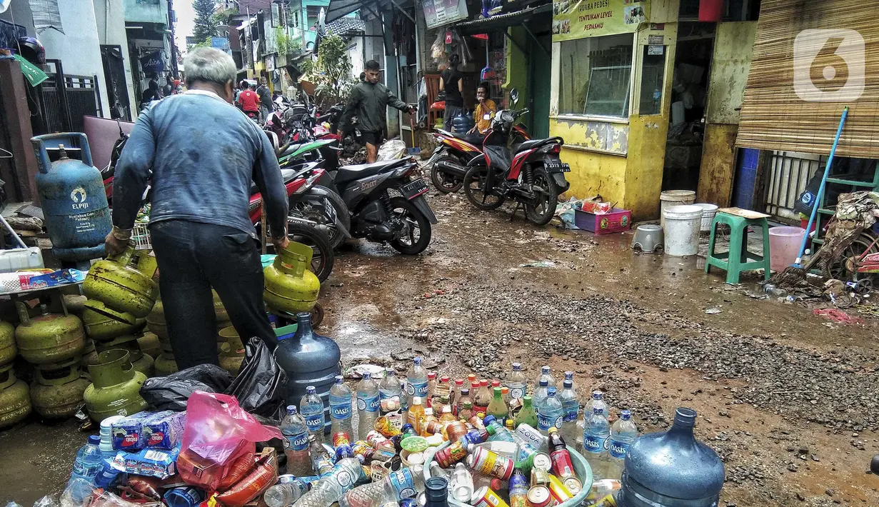 Warga beres-beres usai banjir di Kebalen, Jakarta, Minggu (21/2/2021). Banjir yang terjadi kemarin karena curah hujan yang tinggi meninggalkan sampah di rumah warga. (Liputan6.com/Johan Tallo)