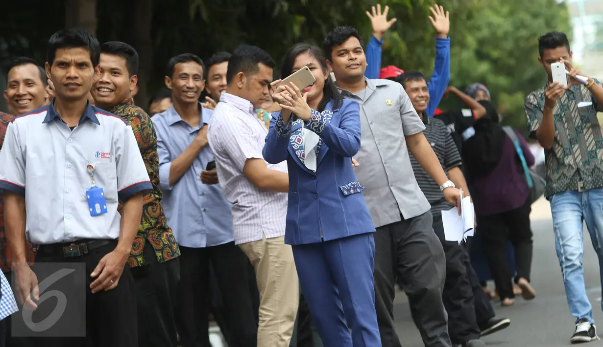 Pekerja menanti iring-iringan rombongan Raja Arab Saudi Salman bin Abdulaziz al-Saud melintas di Jalan MH Thamrin, Jakarta, Kamis (2/3). Saat rombongan Raja Salman melintas sejumlah pekerja antusias untuk melihat langsung. (Liputan6.com/Immanuel Antonius)