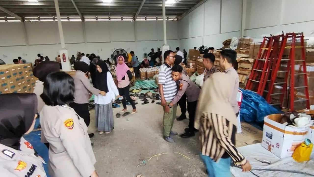Pemeriksaan pekerja pelipatan surat suara Pemilu 2024 oleh personel Polresta Pekanbaru di gudang KPU Pekanbaru.
