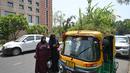 <p>Orang-orang berbicara dengan pengemudi bajaj Mahender Kumar&nbsp; saat ia duduk di kendaraannya dengan 'taman' di atapnya, di New Delhi, India pada 2 Mei 2022. Bajaj kuning dan hijau ada di mana-mana di jalan-jalan New Delhi tetapi kendaraan Mahendra Kumar sangat menonjol -- ia memiliki taman di atapnya bertujuan untuk menjaga penumpang tetap sejuk selama musim panas yang menyengat. (Money SHARMA / AFP)</p>