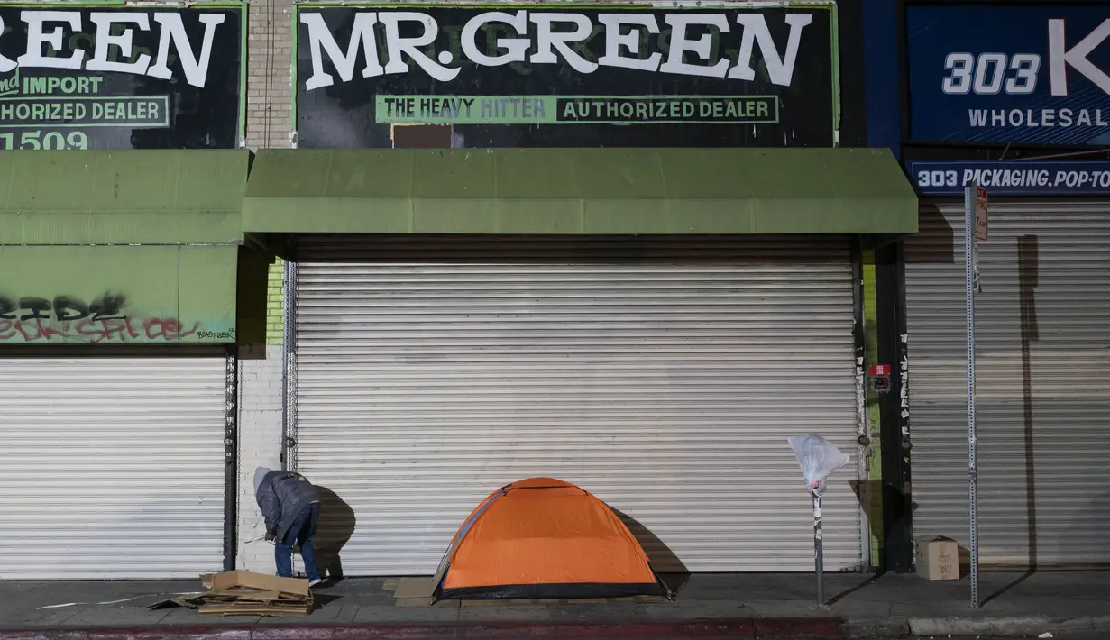 Seorang tunawisma berdiri di samping tendanya di Los Angeles, Rabu (14/12/2022). Tunawisma yang merajalela telah lama menjadi permasalahan utama yang nyata di Los Angeles. (AP Photo/Jae C. Hong)