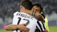  Dybala (belakang) memekuk Mario Mandzukic usai mencetak gol ke gawang Fiorentina, Senin (14/12/2015) dini hari WIB. Direktur Olahraga Juventus, Beppe Marotta, menegaskan takkan menjual Dybala dengan harga berapapun. (Reuters/Giorgio Perottino)