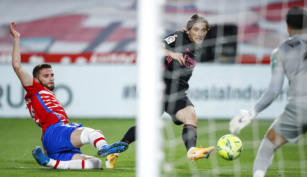 Pemain Real Madrid Luka Modric (tengah) mencetak gol ke gawang Granada pada pertandingan La Liga di Stadion Los Carmenes, Granada, Spanyol, Kamis (13/5/2021). Real Madrid menang telak 4-1 atas Granada. (AP Photo/Fermin Rodriguez)