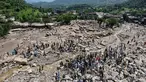 Pemandangan dari udara menunjukkan para korban banjir berkumpul di dekat rumah-rumah yang rusak di sepanjang tepi sungai yang dikelilingi batu-batu besar di distrik Buner, provinsi Khyber Pakhtunkhwa, Pakistan pada 17 Agustus 2025. (Abdul MAJEED/AFP)